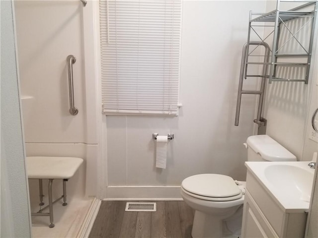 bathroom featuring visible vents, toilet, wood finished floors, baseboards, and vanity