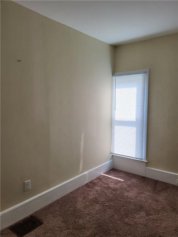 empty room with visible vents, baseboards, and carpet floors