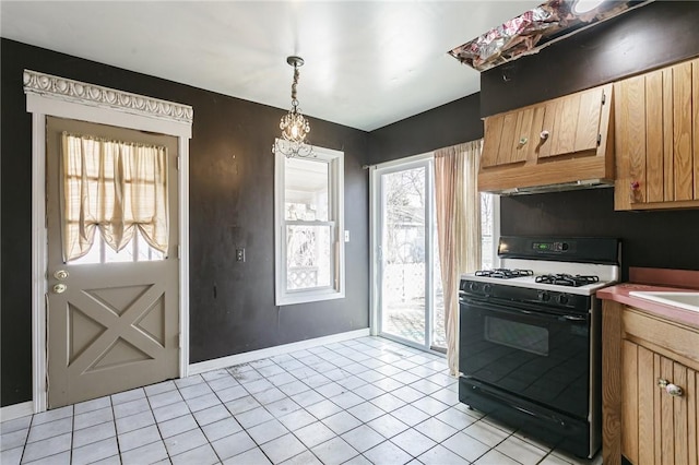 kitchen featuring gas stove, baseboards, pendant lighting, and light tile patterned floors