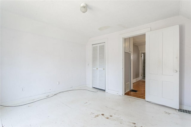 spare room with visible vents and lofted ceiling