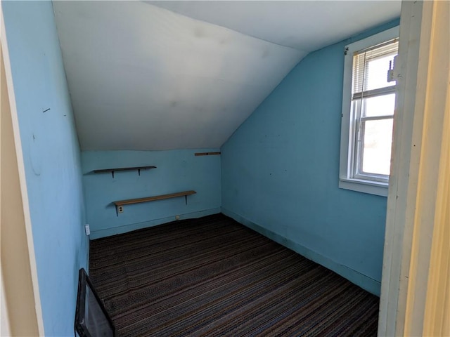 additional living space featuring baseboards and lofted ceiling