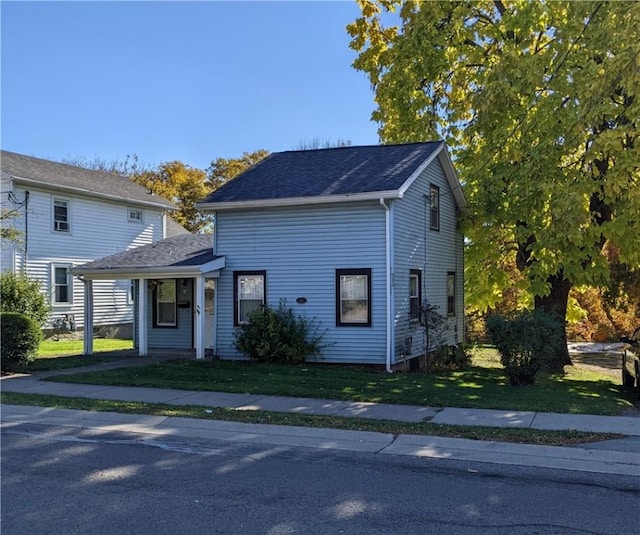 traditional-style home with a front lawn and roof with shingles