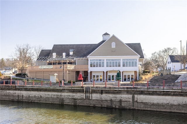 back of house featuring a patio, a balcony, and a water view