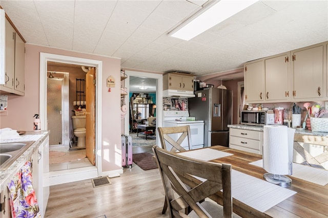 kitchen with visible vents, under cabinet range hood, light countertops, appliances with stainless steel finishes, and light wood-style floors