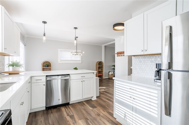 kitchen featuring appliances with stainless steel finishes, white cabinets, crown molding, decorative backsplash, and dark wood-style flooring