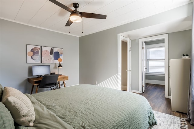 bedroom featuring a ceiling fan, crown molding, wood finished floors, and baseboards