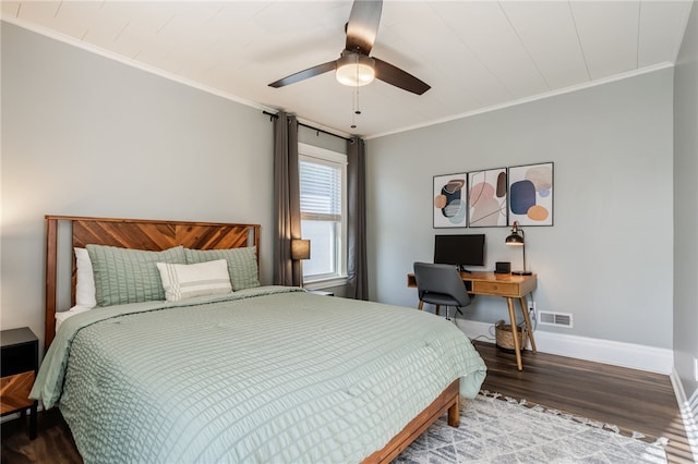 bedroom with visible vents, baseboards, ornamental molding, wood finished floors, and a ceiling fan