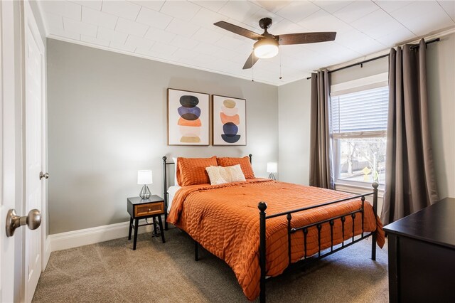 carpeted bedroom with baseboards, a ceiling fan, and crown molding