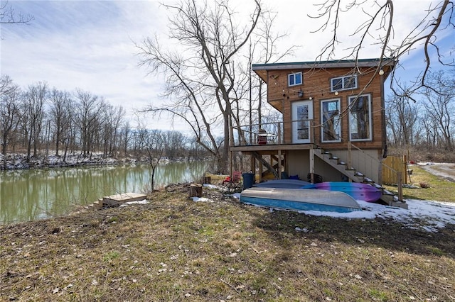 rear view of house with stairway and a water view