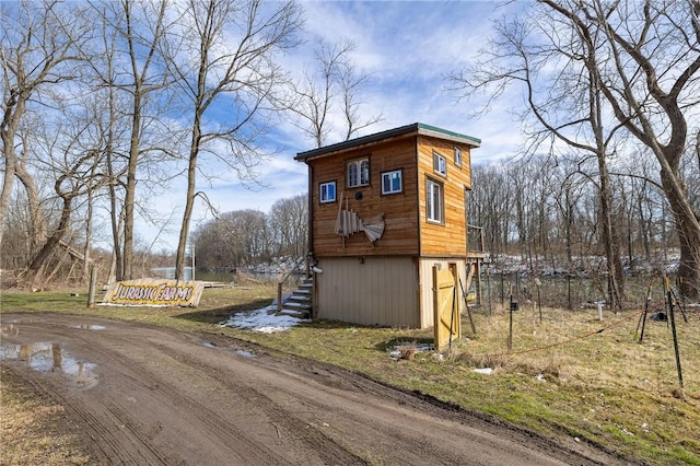 view of outdoor structure featuring stairway and driveway