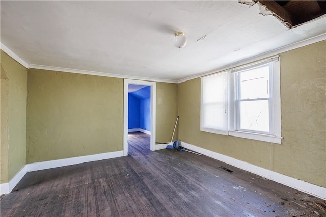 empty room with visible vents, baseboards, and wood finished floors