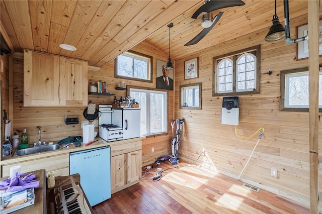 kitchen with light brown cabinets, wood ceiling, white dishwasher, and a sink