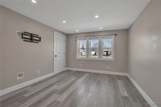 empty room with recessed lighting, wood finished floors, and baseboards