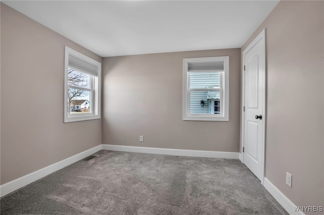 spare room featuring visible vents, baseboards, and carpet