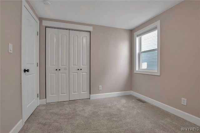 unfurnished bedroom featuring visible vents, baseboards, a closet, and carpet flooring