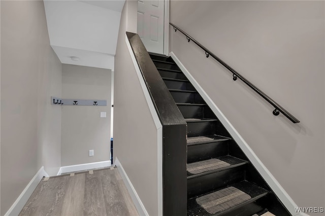 stairway with baseboards and wood finished floors