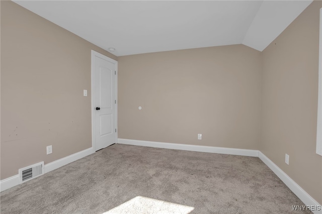 unfurnished room featuring lofted ceiling, carpet, visible vents, and baseboards