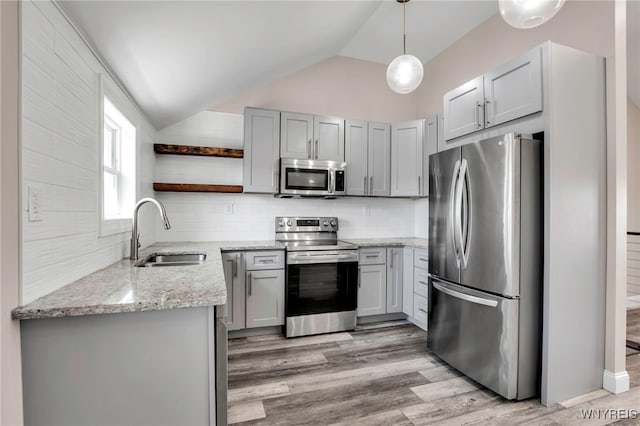 kitchen featuring a sink, light stone countertops, lofted ceiling, appliances with stainless steel finishes, and open shelves