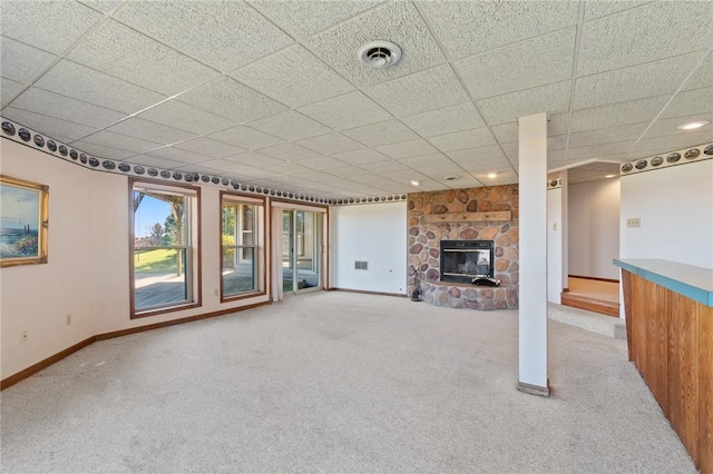 unfurnished living room with visible vents, baseboards, carpet flooring, and a fireplace