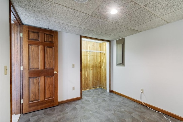 unfurnished bedroom with baseboards and a drop ceiling