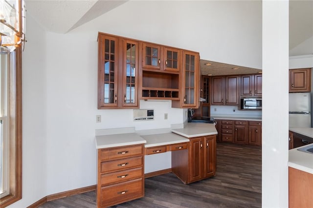 kitchen featuring light countertops, glass insert cabinets, dark wood-style flooring, and appliances with stainless steel finishes