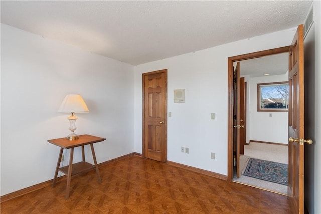 unfurnished room with visible vents, a textured ceiling, and baseboards