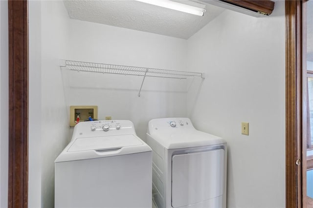 laundry room with washer and clothes dryer, laundry area, and a textured ceiling