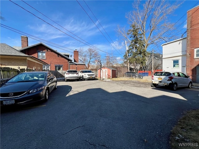 uncovered parking lot with a storage unit and fence