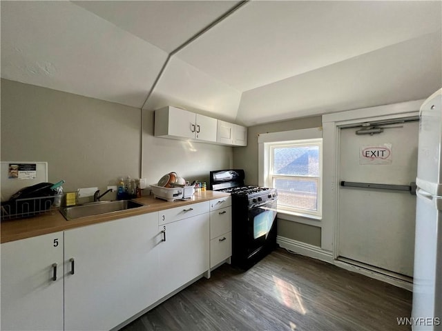 kitchen with black range with gas stovetop, lofted ceiling, dark wood-style floors, white cabinetry, and a sink