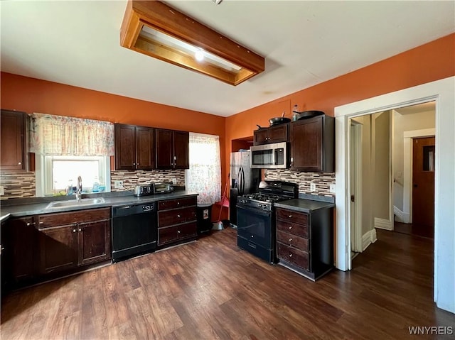 kitchen featuring dark countertops, plenty of natural light, black appliances, and a sink