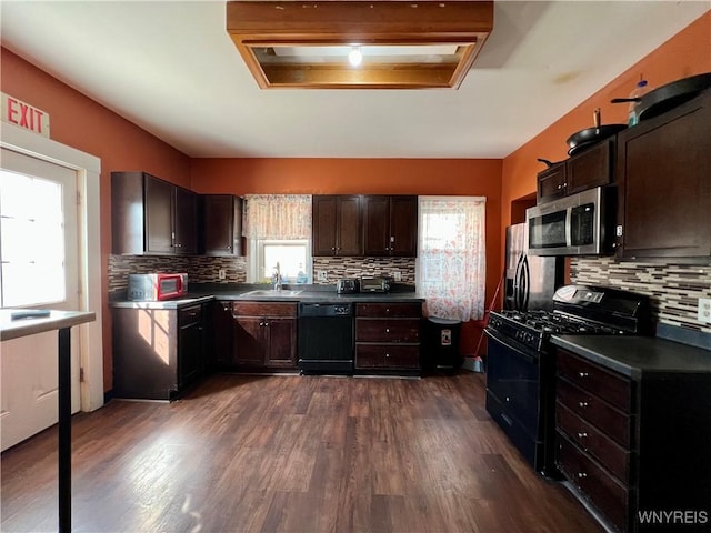 kitchen featuring dark brown cabinets, dark countertops, and black appliances