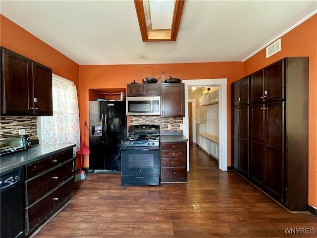 kitchen featuring visible vents, a skylight, dark wood-style flooring, black appliances, and dark brown cabinets