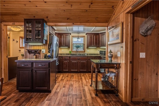 kitchen with dark wood-style flooring, a sink, dark brown cabinets, glass insert cabinets, and wooden ceiling