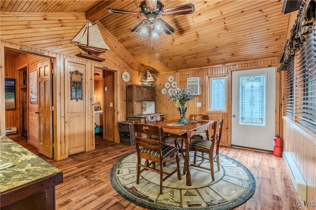 dining room featuring wooden walls, lofted ceiling with beams, and light wood-style floors