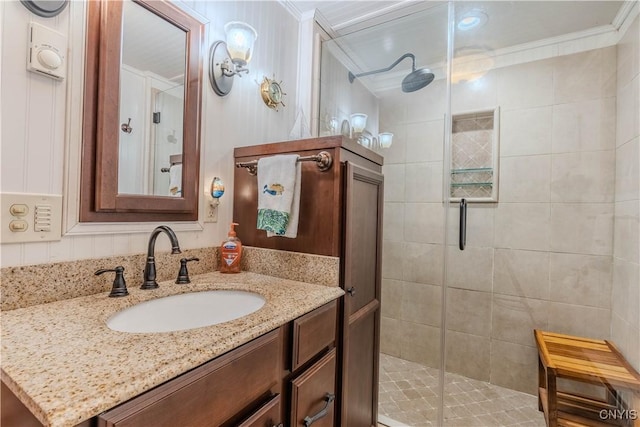 full bathroom featuring vanity, ornamental molding, and a shower stall