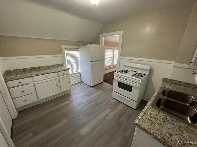 kitchen featuring a sink, wood finished floors, white cabinetry, white appliances, and vaulted ceiling