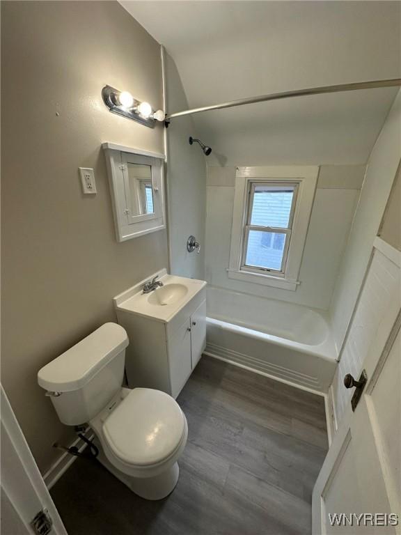 bathroom with vanity, wood finished floors, toilet, and washtub / shower combination