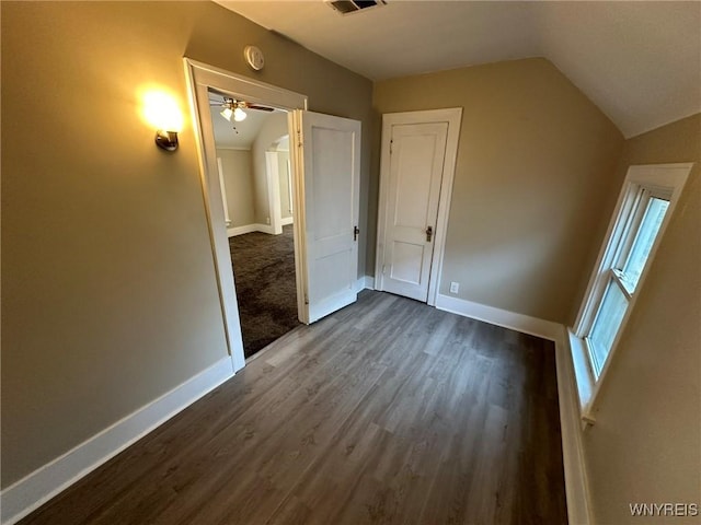 additional living space with visible vents, baseboards, dark wood-type flooring, and vaulted ceiling