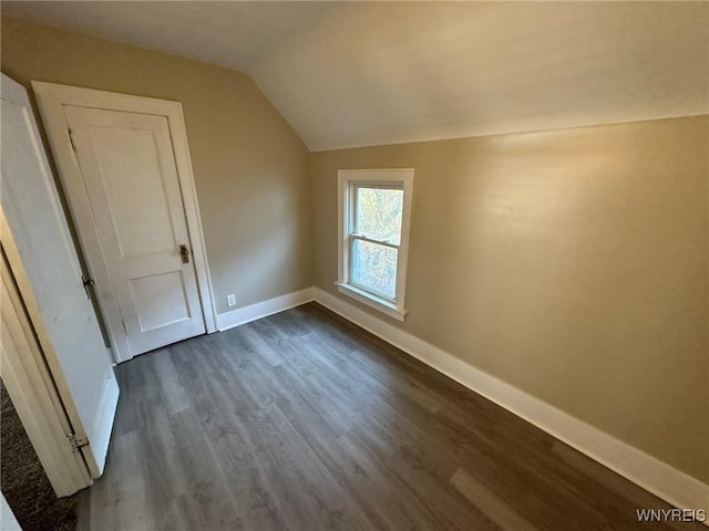 bonus room featuring baseboards, dark wood finished floors, and vaulted ceiling