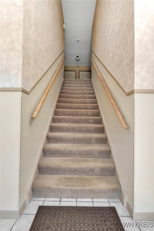 staircase with tile patterned floors