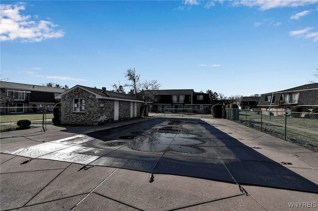 view of swimming pool with a patio area, fence, and a residential view