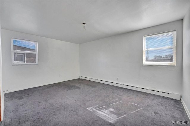 empty room with a baseboard heating unit and carpet