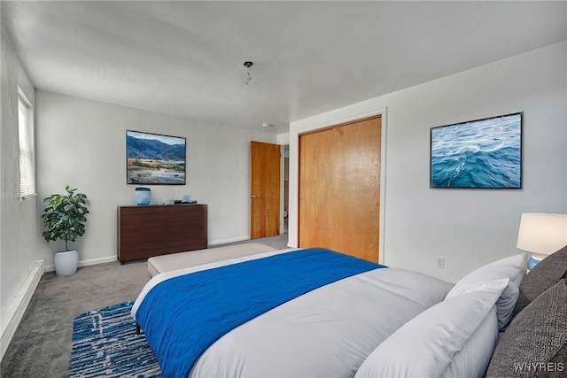 bedroom featuring a closet, baseboard heating, baseboards, and carpet floors