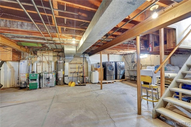 unfinished below grade area featuring washing machine and clothes dryer, gas water heater, a heating unit, and stairs