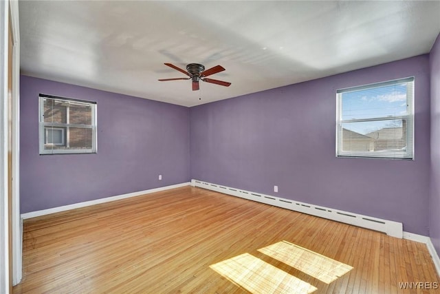 unfurnished room featuring baseboards, baseboard heating, wood finished floors, and a ceiling fan