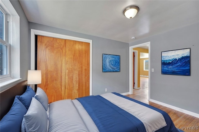 bedroom featuring a closet, baseboards, and light wood-style flooring