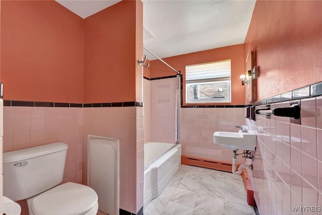 full bath featuring toilet, marble finish floor, a baseboard heating unit, tile walls, and shower / bath combination