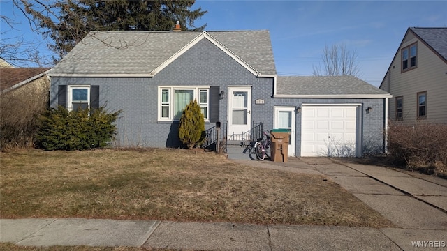 view of front of house featuring a front yard, roof with shingles, concrete driveway, a garage, and brick siding