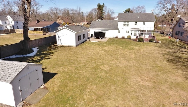 view of yard with fence, a shed, a residential view, an outdoor structure, and a patio area