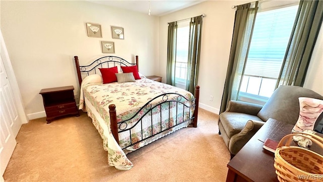 carpeted bedroom with multiple windows and baseboards